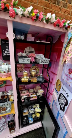 A pink room with a shelf full of cakes.