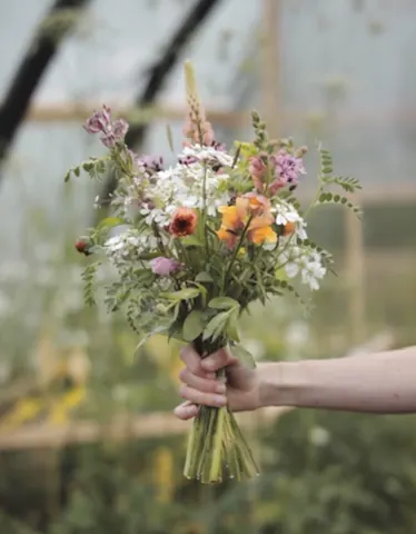A person holding a bouquet of flowers.