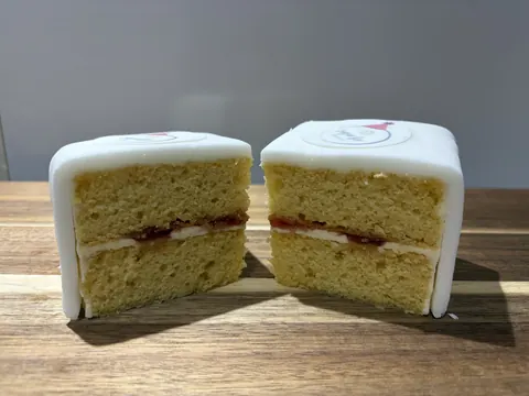 A cake with white frosting and red jam.