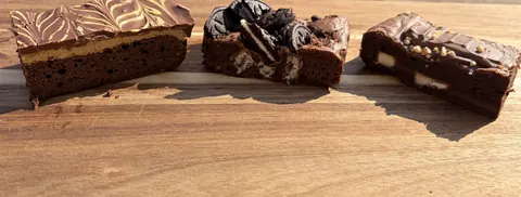 A slice of chocolate cake with a white frosting and a black and white cookie.