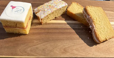 A wooden table with three cakes on it.