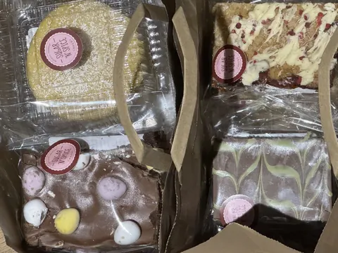 A box of cakes with a bag of cookies.