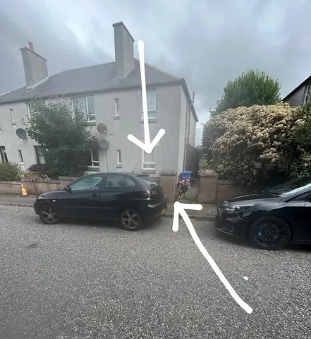 A black car is parked next to a blue car.