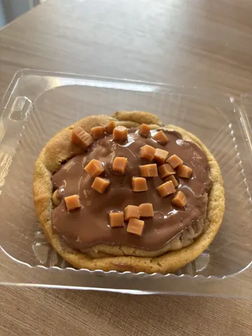 A cookie with chocolate and caramel toppings.