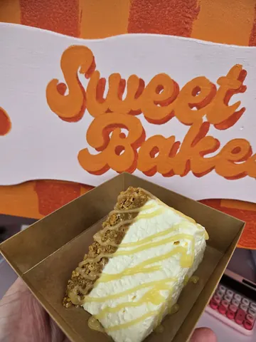 A slice of cake with white icing and caramel drizzle.