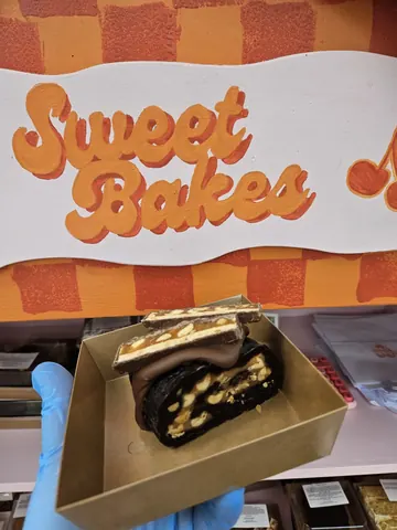 A box of chocolate cake with nuts on top.