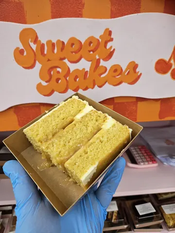 A box of cake is being held by a person.