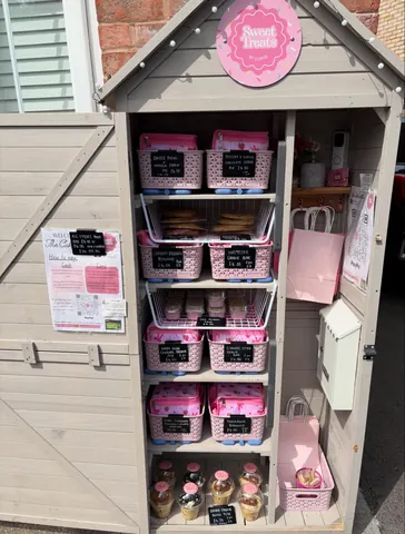 A small pink building with a sign that says "Sweetie Pie's" on it.