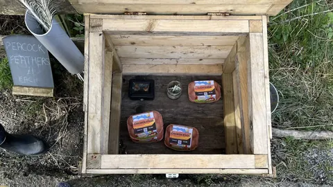A wooden box with a black object inside.