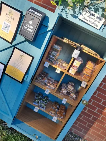 A small blue building with a sign that says "Cash in Box" on it.