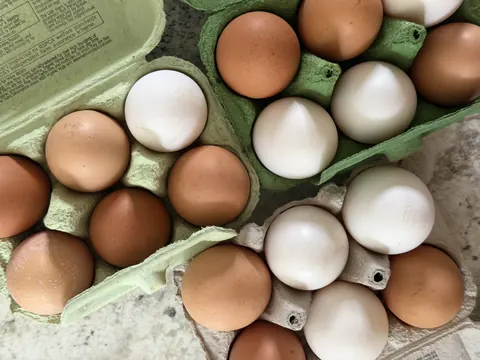 A carton of eggs is sitting on a table.