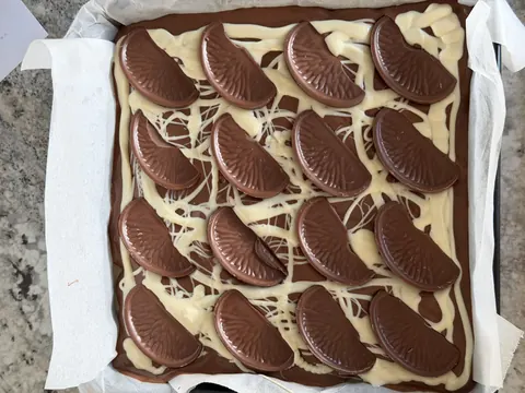 A chocolate dessert with white icing and chocolate chips.