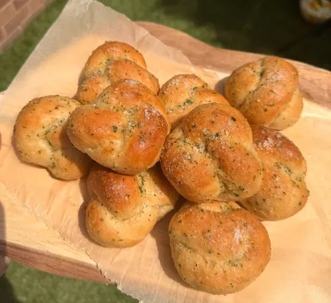 A wooden tray with a bunch of bread on it.