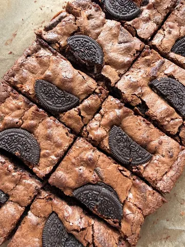 A chocolate brownie with Oreo cookies on top.