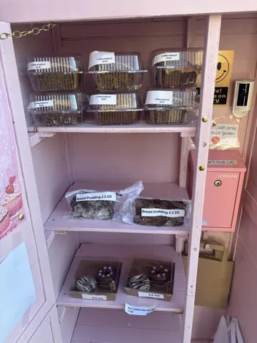 A pink shelf with food items on it.