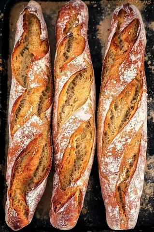 Three loaves of bread are on a table.