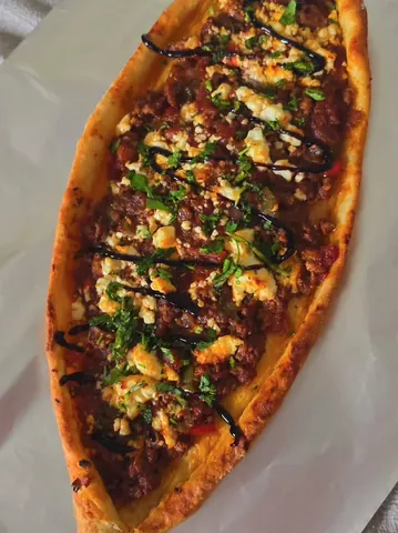 A pizza with black sauce and cheese on it.