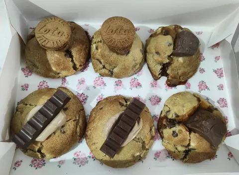 A box of chocolate chip cookies with chocolate chips and white frosting.