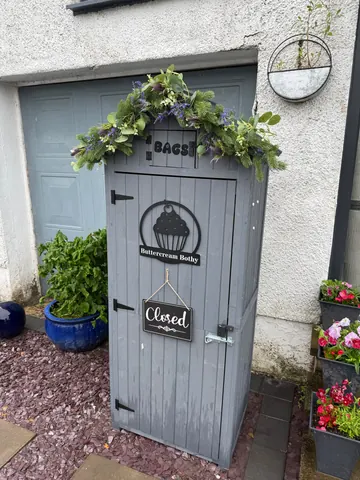 A small grey shed with a sign that says "closed" on it.