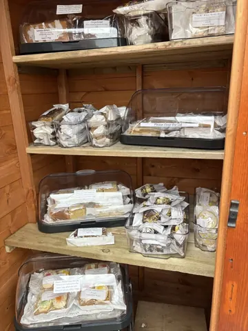 A wooden shelf with a variety of food items on it.