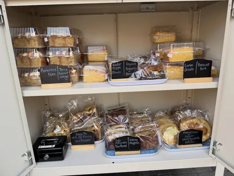 A display case filled with various types of cakes and pastries.