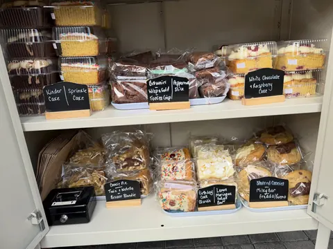 A display of various cakes and pastries in a bakery.