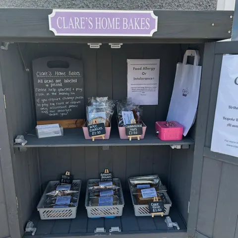 A small wooden shelf with a sign that says "Clare's Home Bakes" on it.