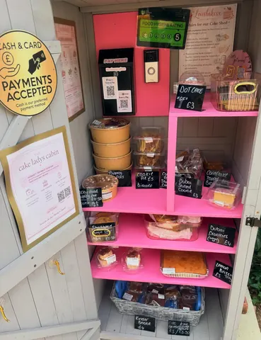 A pink and white display case with a variety of food items.