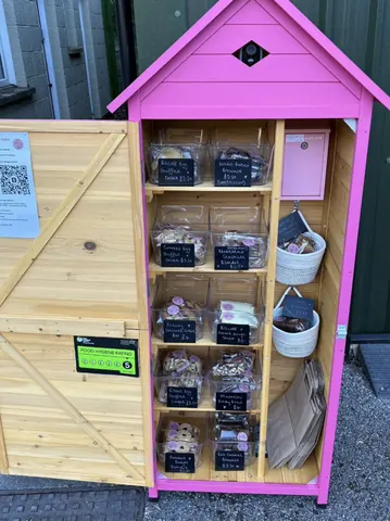 A pink shed with a sign that says "Pink shed".