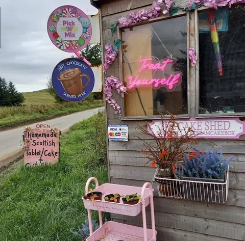 A pink stand with a sign that says "Pick Mix" on it.