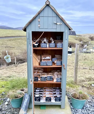 A small wooden structure with a sign that says "Farm Shop" on it.