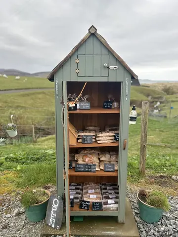 A small green shed with a sign that says "O" on it.