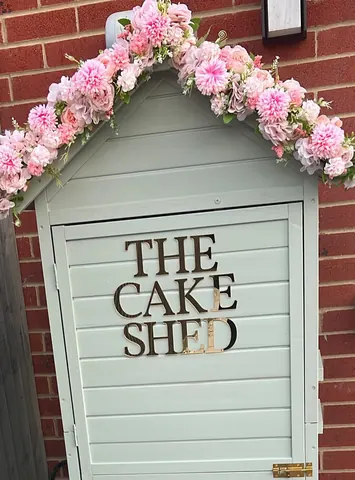 A small building with a sign that says "The Cake Shed".