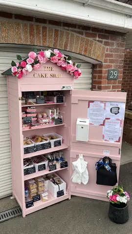A pink and white cake shop with a pink door.
