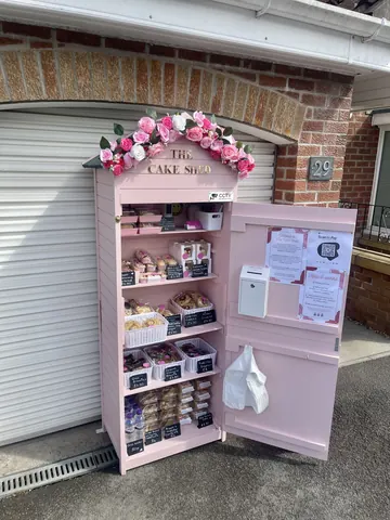 A pink cake stand with a sign on it.