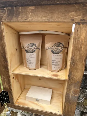 Two bags of coffee are sitting in a wooden box.