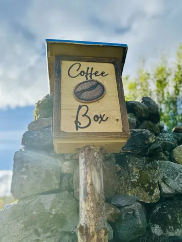 A wooden box with a sign that says coffee box.