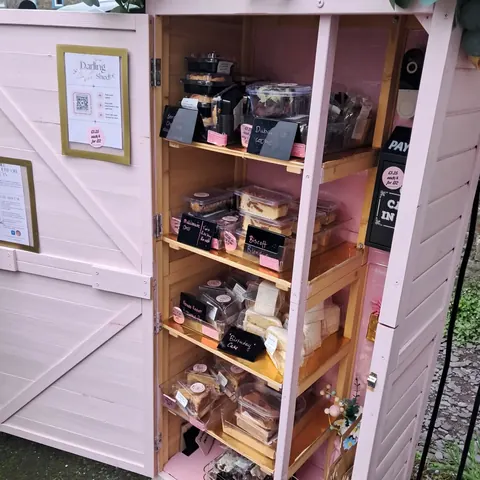 A pink shed with a wooden door and a sign that says "Durham".