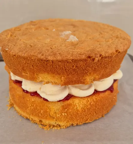 A cake with white frosting and red jam.