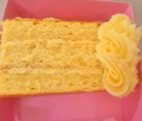 A slice of cake with a yellow frosting.