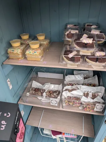 A blue wooden shelf with a variety of food items on it.