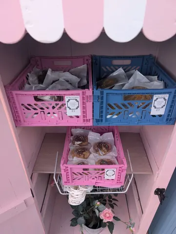 A pink and blue shelf with a bunch of bags on it.