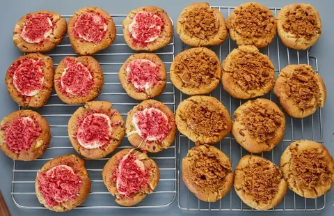 A tray of cookies with pink frosting.