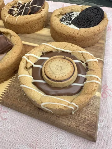 A wooden cutting board with a cookie on it.