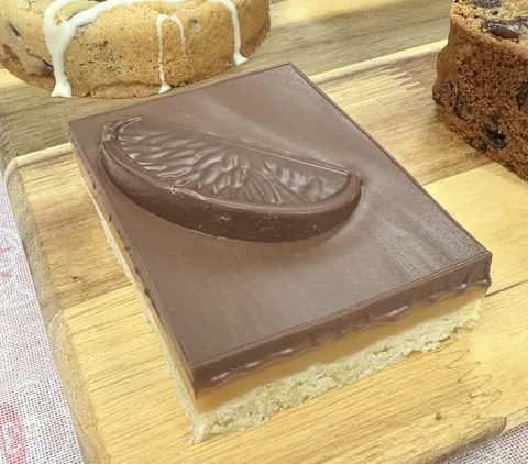 A slice of chocolate cake with a slice of lemon on top.