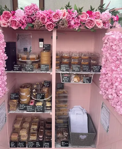 A pink and white display case filled with various pastries.