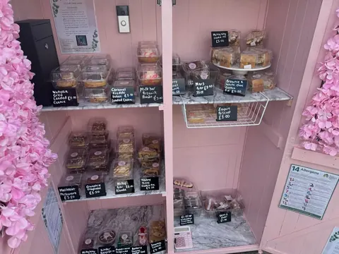 A pink room with a shelf full of food.