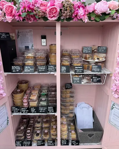 A pink cabinet with a sign that says "Muffins" on it.