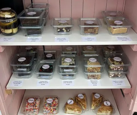 A display of various desserts in plastic containers.