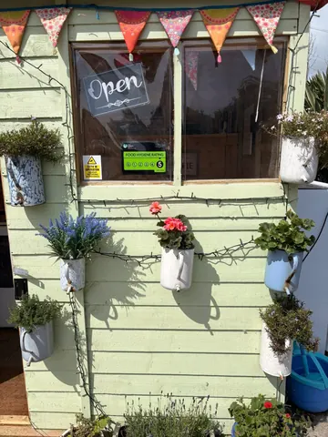 A green building with a sign that says "open" on it.